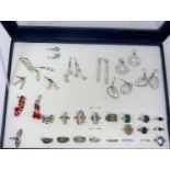 A jewellery display box with a large selection of costume rings and earrings