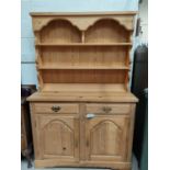 A modern pine dresser with double cupboards and drawers bellow