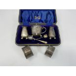 A hallmarked silver 3 piece cruet with serrated rims and ball feet, cased, Sheffield; a pair of