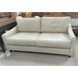 A modern cream leather two seater settee.