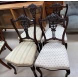 A set of seven Victorian mahogany salon chairs with carved backs, on cabriole legs.