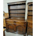 An oak reproduction Welsh dresser with 3 height delft rack over 2 cupboards and 2 drawers