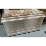 A modern cream painted ottoman with deeply buttoned patterned fabric top and lattice work front
