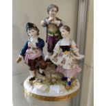 An Augustus Rex' style china group of 3 child musicians, height 18.5cm (flute a.f.)