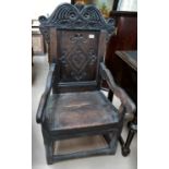 An 18th Century oak Wainscott chair with panelled seat, carved decoration.
