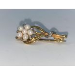 A seed pearl and diamond brooch in the form of a flower, unmarked