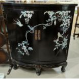 A 20th century black lacquer Chinese style floor standing corner cupboard with mother of pearl