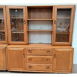 An Ercol light elm full height sideboard, with 2 glazed cupboards and centre shelves over drawers