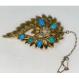 A turquoise and diamond brooch in the form of a flower head surrounded by leaves, in 18 carat