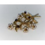 A 9 carat hallmarked gold brooch, floral spray with 4 flowerheads set seed pearls and garnets, the