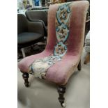 A Victorian scoop back nursing chair with central beaded decoration, on turned legs.
