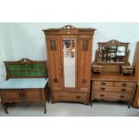 An Edwardian carved oak 3 piece bedroom suite in the Arts Crafts style comprising mirror door