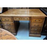 A 1920's solid oak twin pedestal office desk fitted with 9 drawers with brass handles, 122 x 75cm