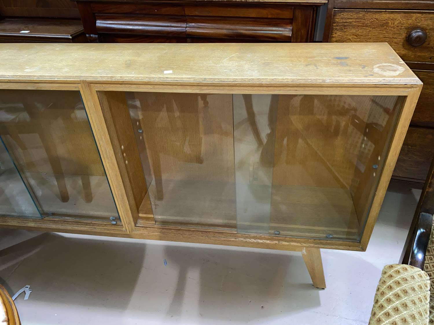 A 1950's pale oak bookcase, sliding glass doors 152cm