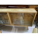 A 1950's pale oak bookcase, sliding glass doors 152cm