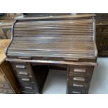 An early 20th Century oak S-shaped roll top pedestal desk with fitted interior, eight drawers