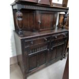 A reproduction carved oak court cupboard with upper cupboard, lower cupboard and drawers