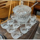 A large cut glass punch bowl and cups