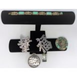 An oriental style bracelet with alternating links of pierced symbols and jade coloured plaques