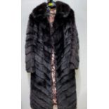 A lady's dark brown full length mink coat, the fur in chevron design