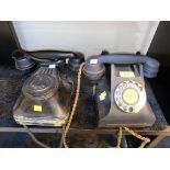 A vintage black Bakelite cased rotary telephone and another similar