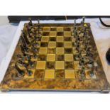 A brass chess set with matching mottled board; a small white & gilt metal chess set with leather