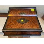 A 19th century Amboyna lap desk with brass inlay and ebonsized borders with fall out writing surface