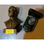 A brass bust of Adolf Hitler and two German badges