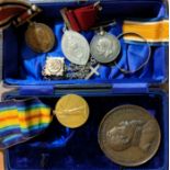 A selection of medals including a large bronze medal, with white metal chains, cross and bracelet