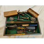 A collection of corkscrews, vintage spectacles and other collectables in a wooden box