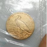 A gold 1909 Liberty five dollar coin with native American and eagle head