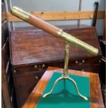 A brass table top telescope on tripod base