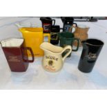 A selection of ceramic pub advertising water jugs