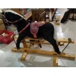 A mid 20th century plush rocking horse with a red saddle & reins on swing pine base (worn)