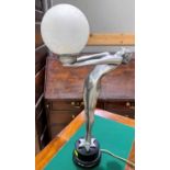 An Art Deco style table lamp, silvered woman holding an opaque globe