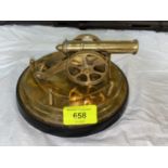 A model brass cannon on circular hardwood stand 17cm diameter