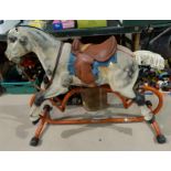 A TRI-ANG late 1950's painted pressed metal rocking horse on tubular stand 100cm length