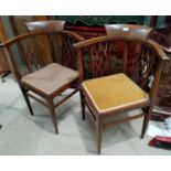 An Edwardian pair of tub shaped corner armchairs in crossbanded mahogany