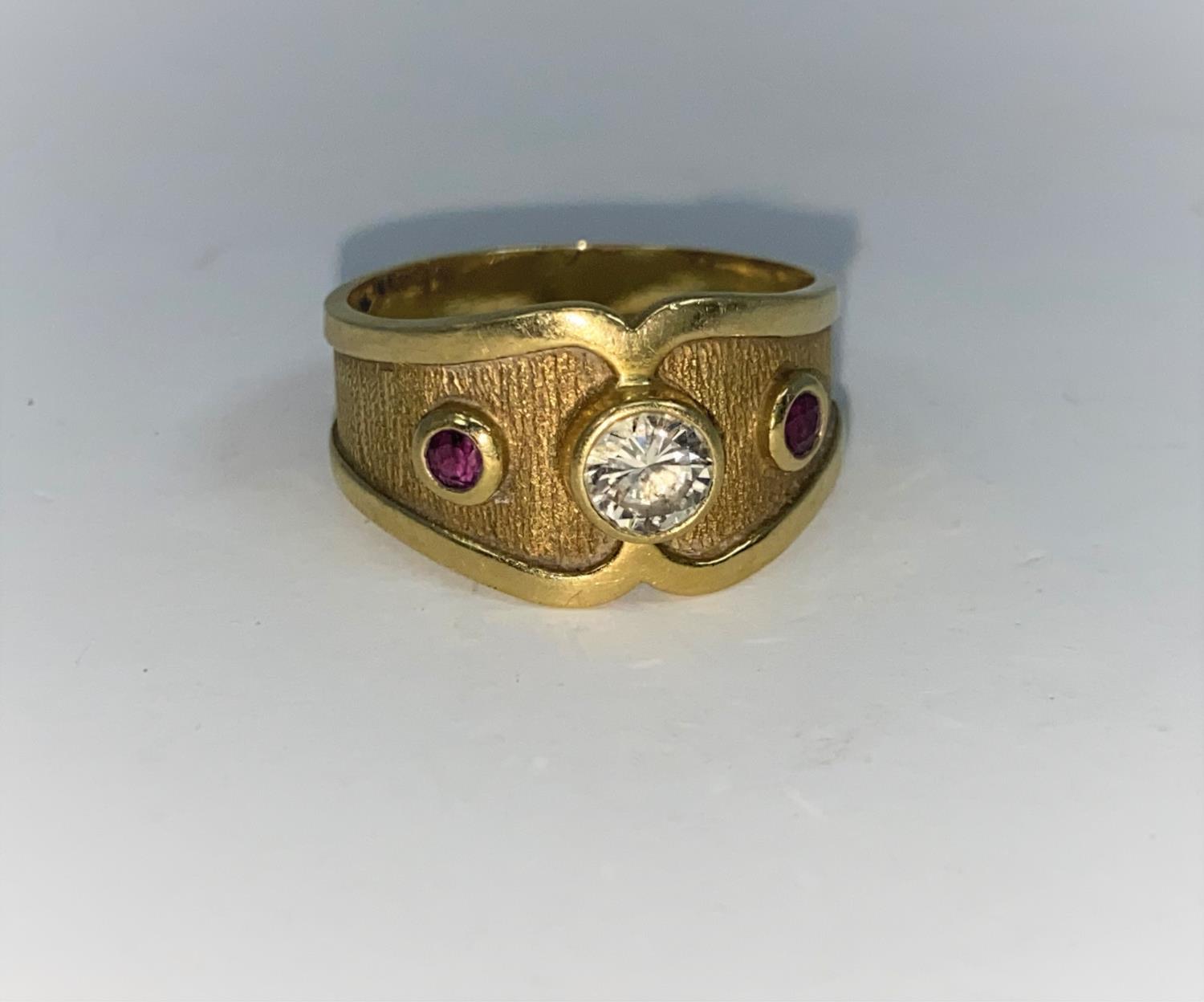 A Victorian style 18 carat hallmarked gold ring with wide shaped shank set with 2 rubied and a