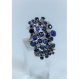A 1970's lady's modernist multi stone diamond and sapphire ring on white metal shank stamped 18ct