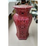 A Chinese style plant stand of baluster form, in pierced pink pottery