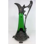 An Art Nouveau green glass wine jug of swelling form, the pewter mounts with embossed decoration
