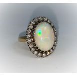 An large oval opal and diamond dress ring stamped 18 ct, 22 diamonds, size Q, gross 10.6g