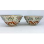 A pair of Chinese bowls finely decorated with dragons, vases etc, light blue interior and bases,