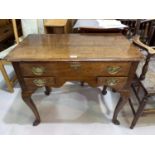 An 18th century crossbanded oak lowboy with rounded corners, shaped apron, and 3 drawers, on