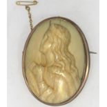 An oval Victorian brooch set with an antique carved ivory half length portrait of a woman at prayer