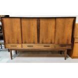 A 1960's Danish Rosewood high sideboard with shelves enclosed by four sliding doors