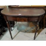 A late Georgian mahogany tea table with'D' end fold-over top, on turned tapering ringed legs,