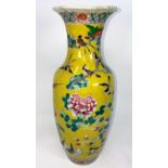 A Chinese famille jaune baluster vase with intricate enamel decoration of birds, flowers and foliage