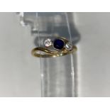 A yellow metal three stone diamond and sapphire ring in crossover setting stamped 18ct 2.6gms